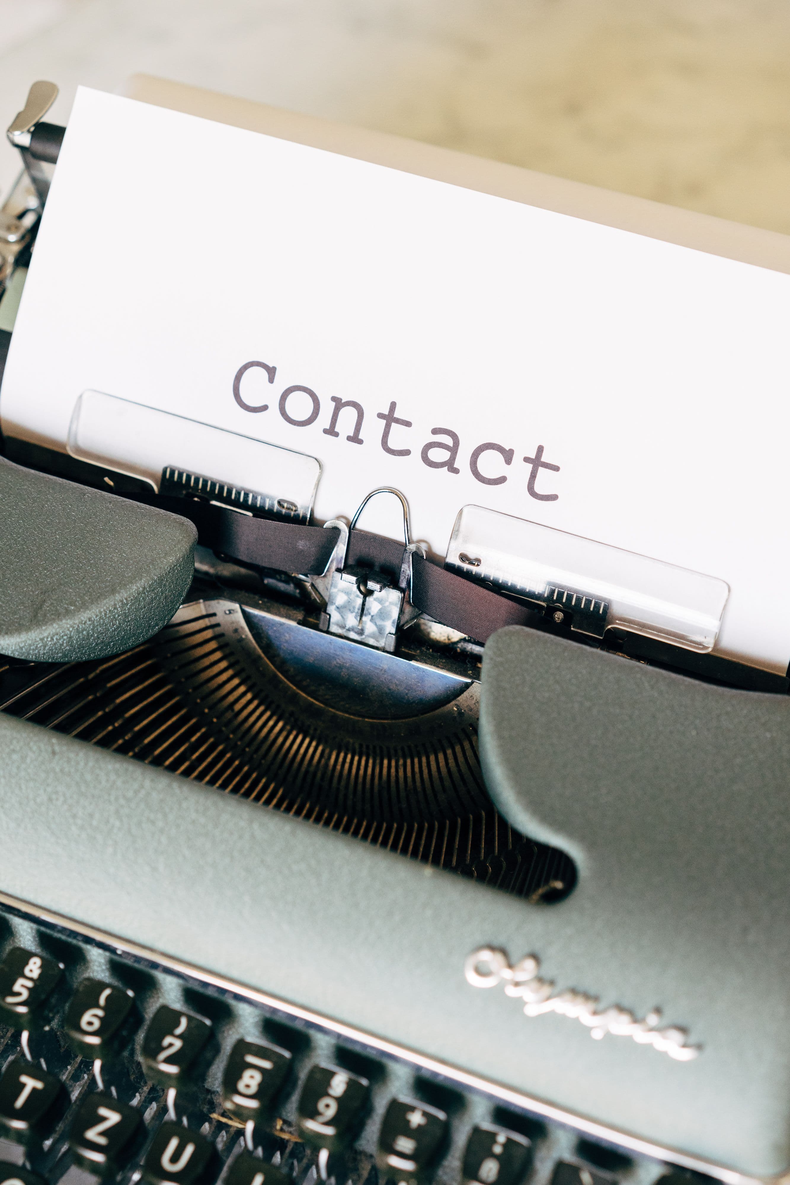 Vintage typewriter with a sheet of paper displaying the word Contact